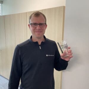 A WithersRavenel employee holding a commemorative glass.