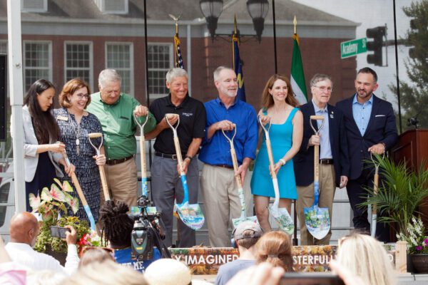 Town of Cary staff on stage holding painted shovels for Downtown Cary Park groundbreaking ceremony