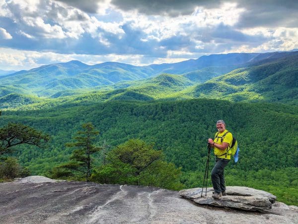 Keith Pugh standing on a bluff overlooking a large forest