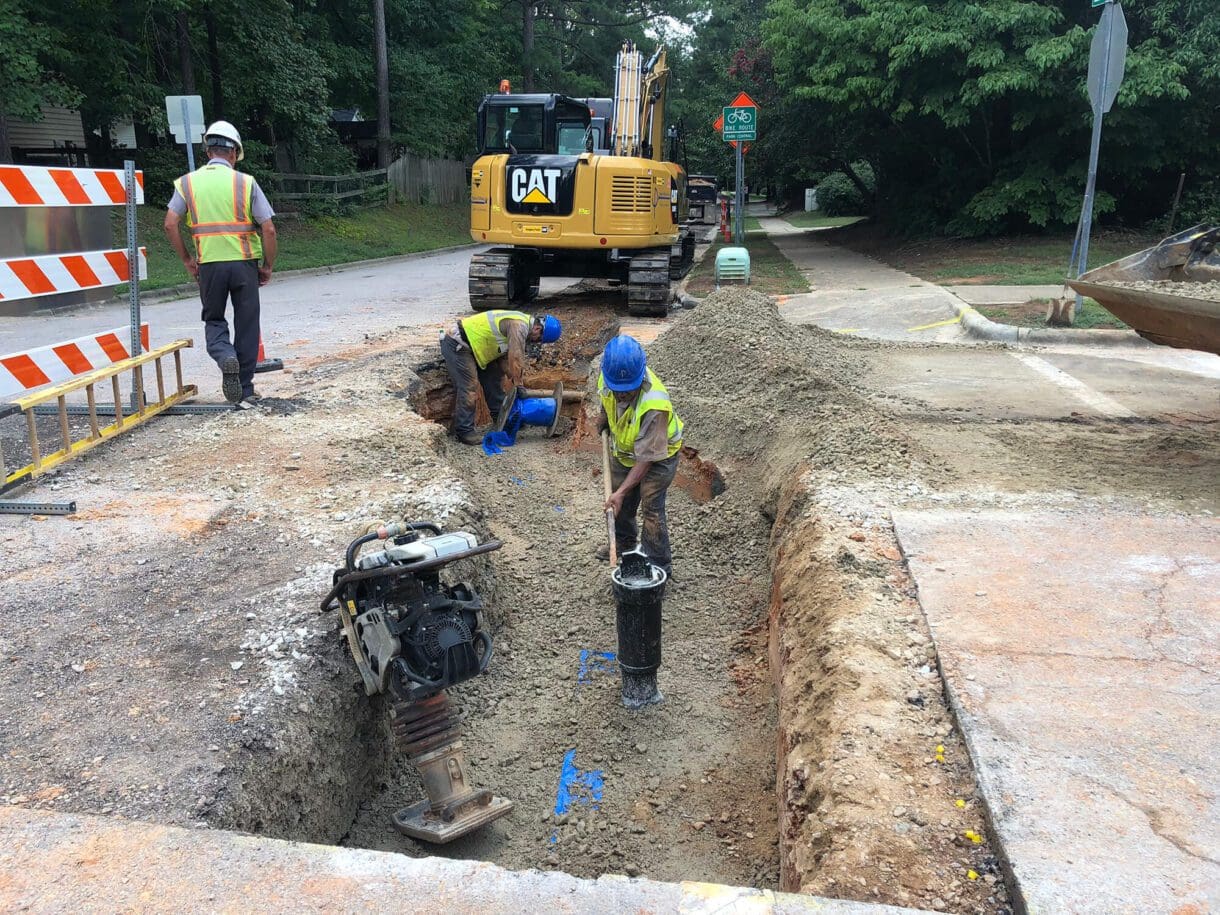 workers preparing a road for utilities