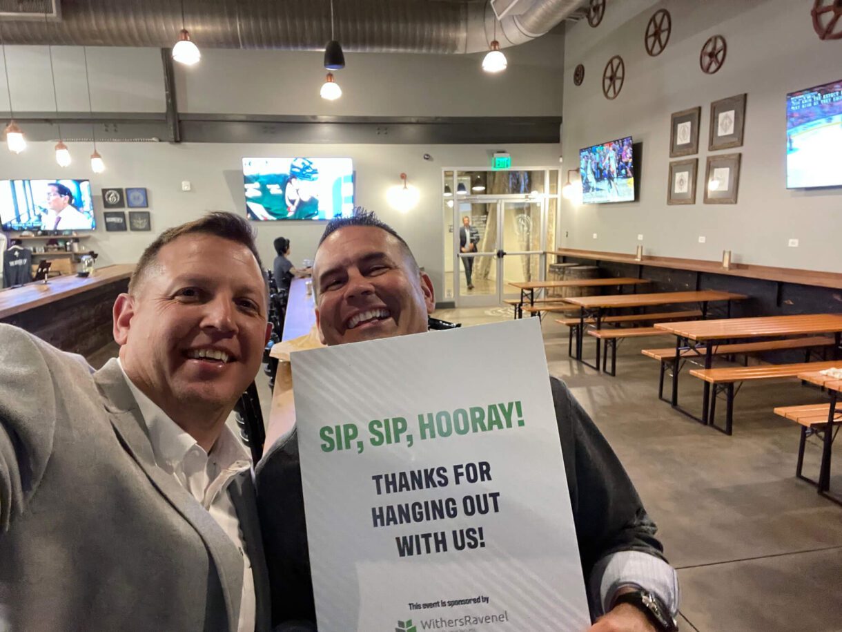 holding a sign that says "sip sip hooray"