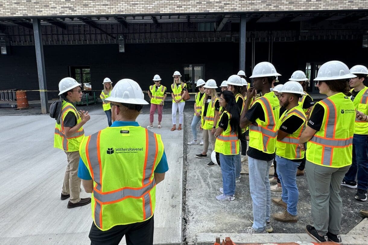 Engineer speaking to interns at a job site