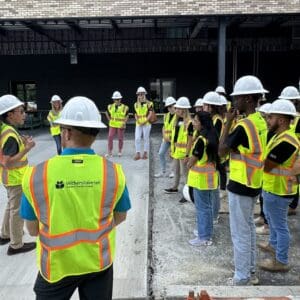 Engineer speaking to interns at a job site