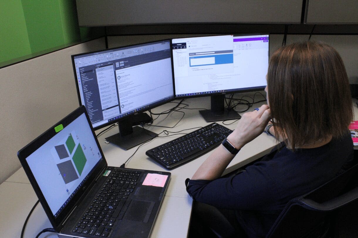 A woman looking at a computer with data