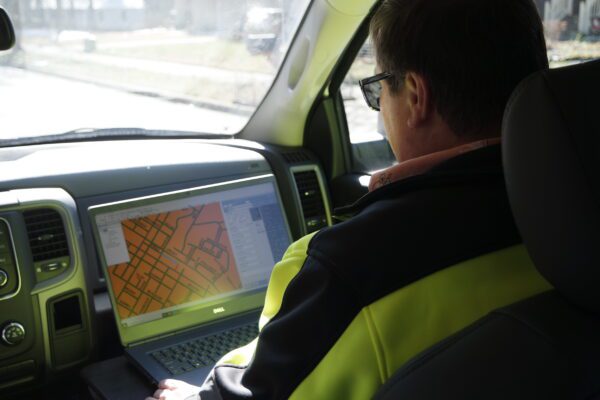 Employee monitoring roadway data on a laptop.