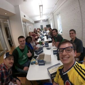 A group of young professionals around a table in a break room