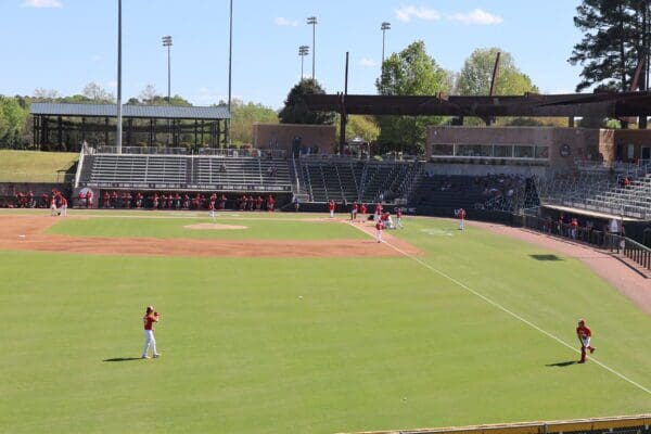 A baseball field with players warming up for a practice session.