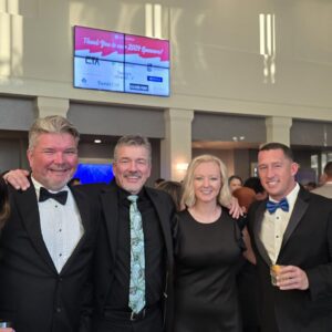 A group of formally dressed professionals at an awards banquet.