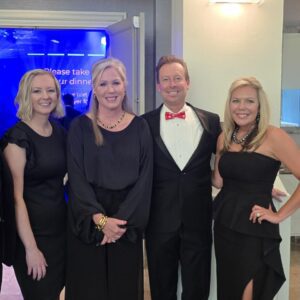 A group of formally dressed professionals at an awards banquet.