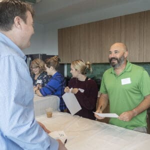 Company employees mingle at Ownership Month event.