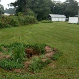 A damaged hole in a yard following a hurricane.