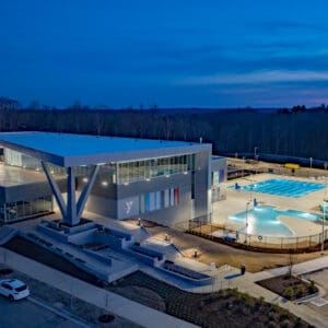 An aerial photo of the new YMCA complex at night showing two pools