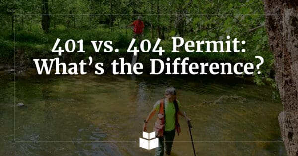 An environmental professional crossing a stream.