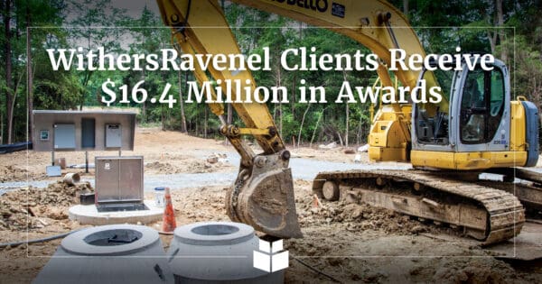 An image of a crane with text overlaying and indicating infrastructure funding awards.