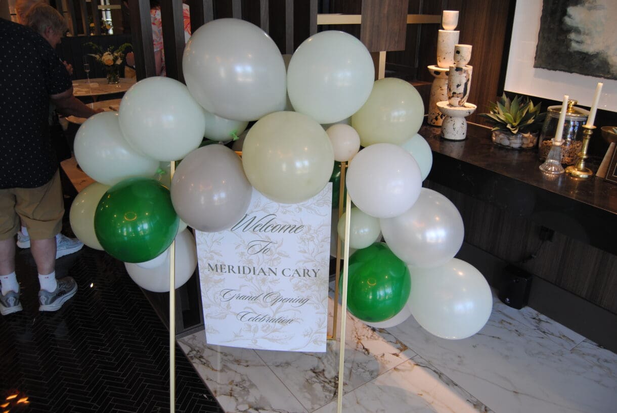Balloon display and welcome sign for The Meridian Cary grand opening celebration in Downtown Cary.