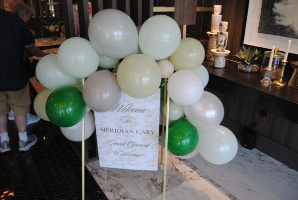 Balloon display and welcome sign for The Meridian Cary grand opening celebration in Downtown Cary.
