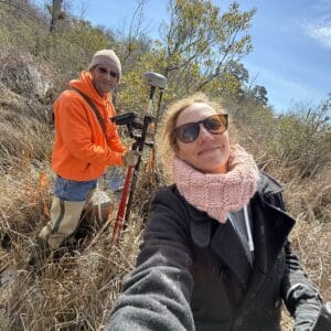 A woman taking a selfie with a professional surveyor.