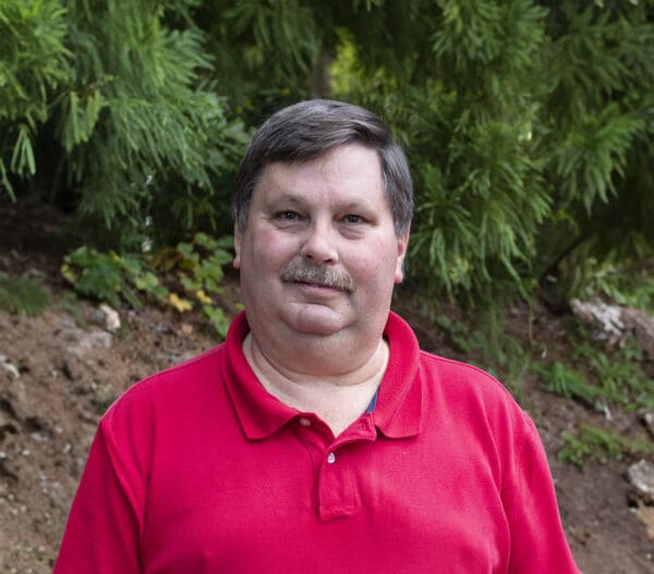 A man with a mustache wearing a red shirt