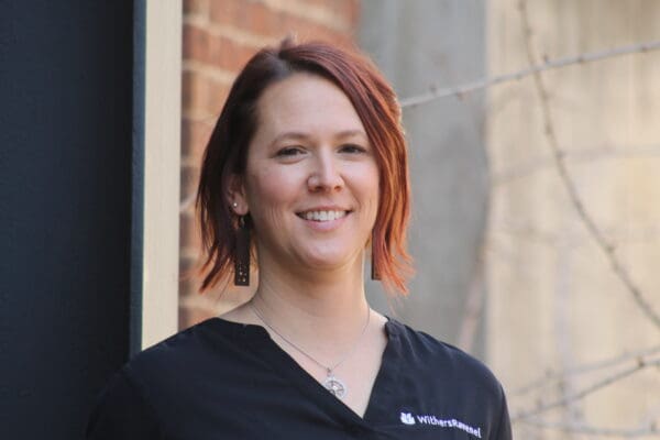 A headshot of a WithersRavenel employee standing in front of a brick column.