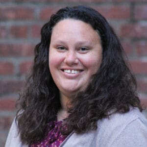 A smiling woman with curly dark hair