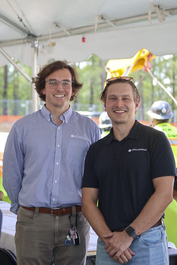Two professionals smiling at an event.