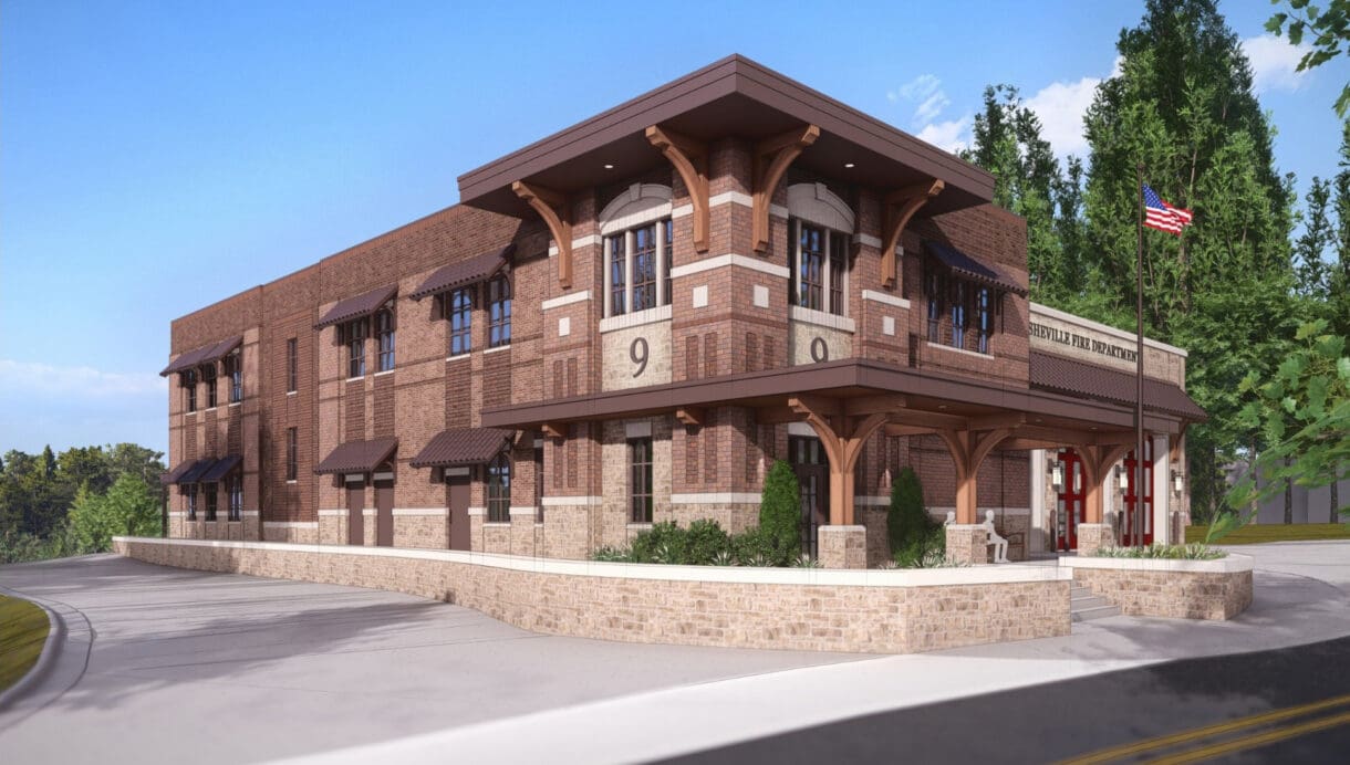 Architectural rendering of the station’s brick side facade and covered corner entrance, with stone retaining walls, a flagpole, and a curved drive.