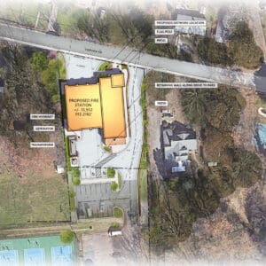 Aerial site plan showing the proposed fire station footprint, parking, driveways, park access route, retaining wall, utilities, and nearby courts.