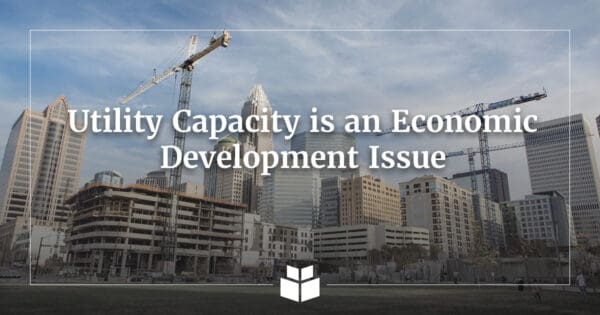 Construction cranes and a partially completed building rise against the Charlotte skyline, with overlaid text reading “Utility Capacity is an Economic Development Issue” and the WithersRavenel logo.